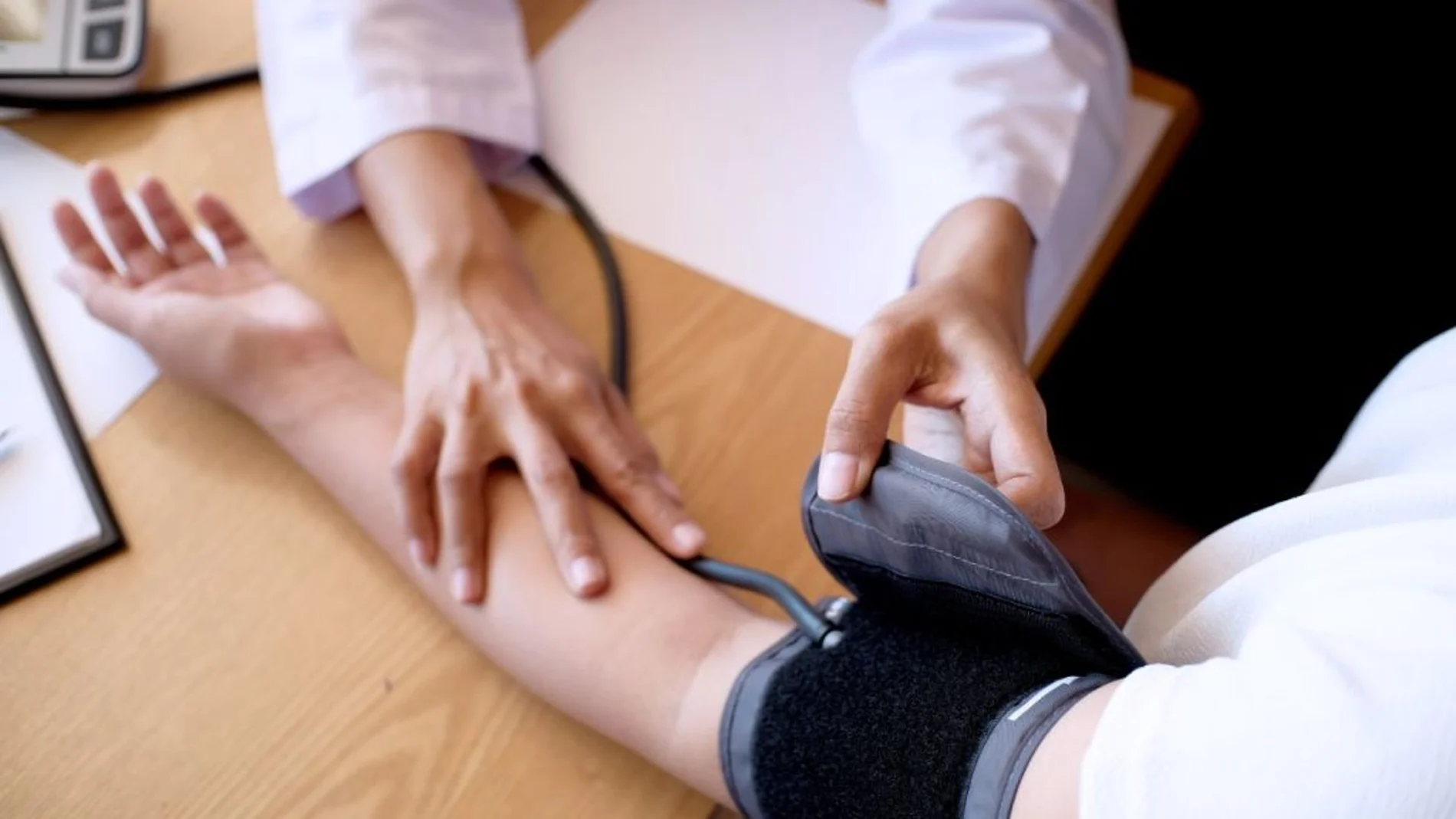 Una médico comprueba la tensión de un paciente
