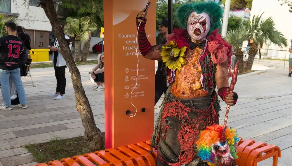 Un muerto viviente cargando su móvil con energía solar en el festival de Sitges