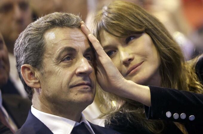 In this Thursday, Oct. 27, 2016 file picture, Carla Bruni-Sarkozy caresses the brow of her husband, the former French President and candidate for France's conservative presidential primary, Nicolas Sarkozy In this Thursday, Oct. 27, 2016 file picture, Carla Bruni-Sarkozy caresses the brow of her husband, the former French President and candidate for France's conservative presidential primary, Nicolas Sarkozy