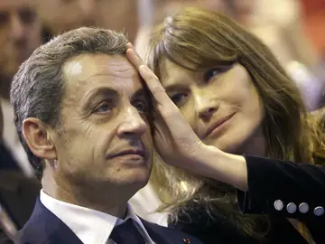 In this Thursday, Oct. 27, 2016 file picture, Carla Bruni-Sarkozy caresses the brow of her husband, the former French President and candidate for France's conservative presidential primary, Nicolas Sarkozy In this Thursday, Oct. 27, 2016 file picture, Carla Bruni-Sarkozy caresses the brow of her husband, the former French President and candidate for France's conservative presidential primary, Nicolas Sarkozy