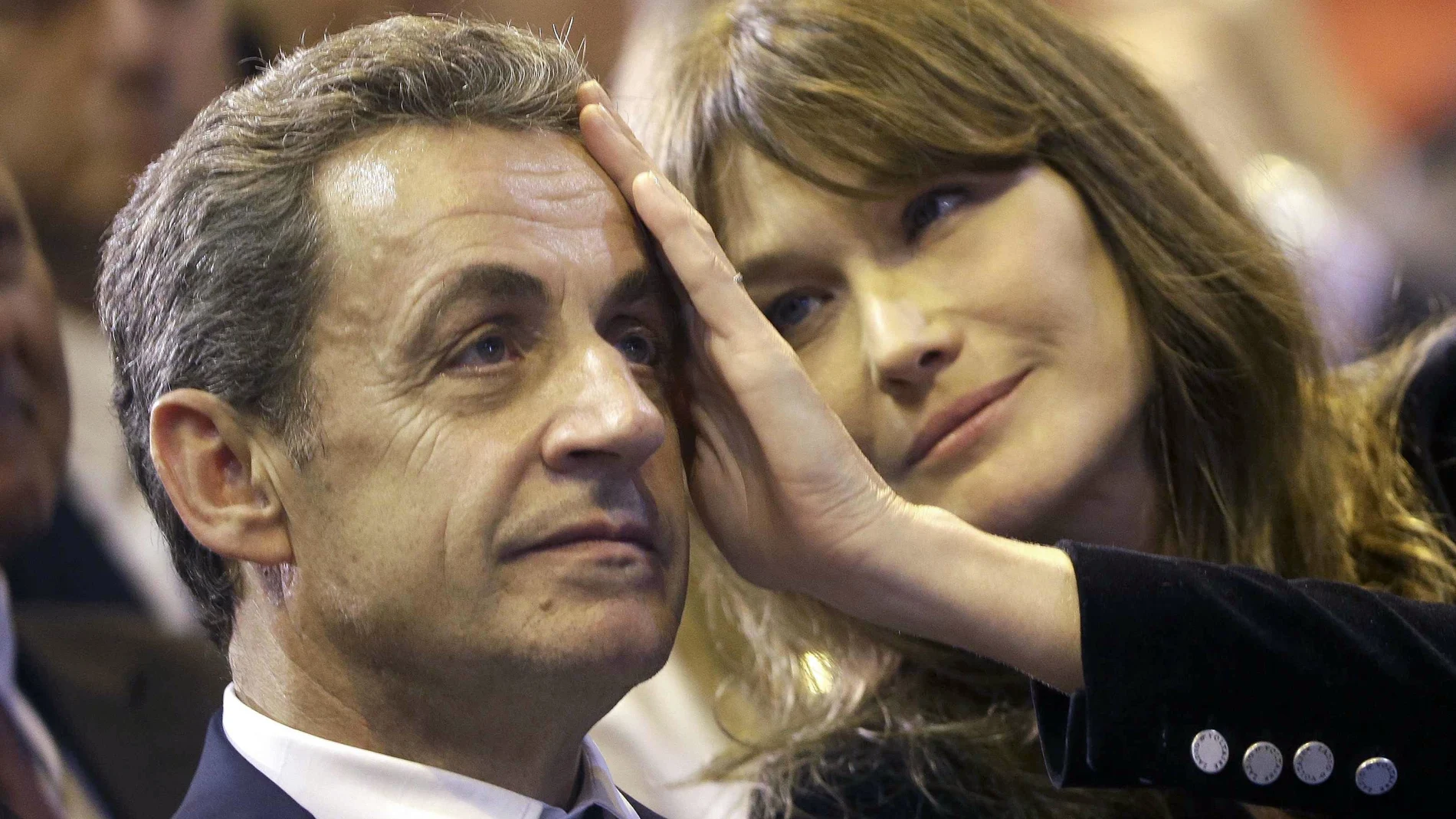 In this Thursday, Oct. 27, 2016 file picture, Carla Bruni-Sarkozy caresses the brow of her husband, the former French President and candidate for France's conservative presidential primary, Nicolas Sarkozy