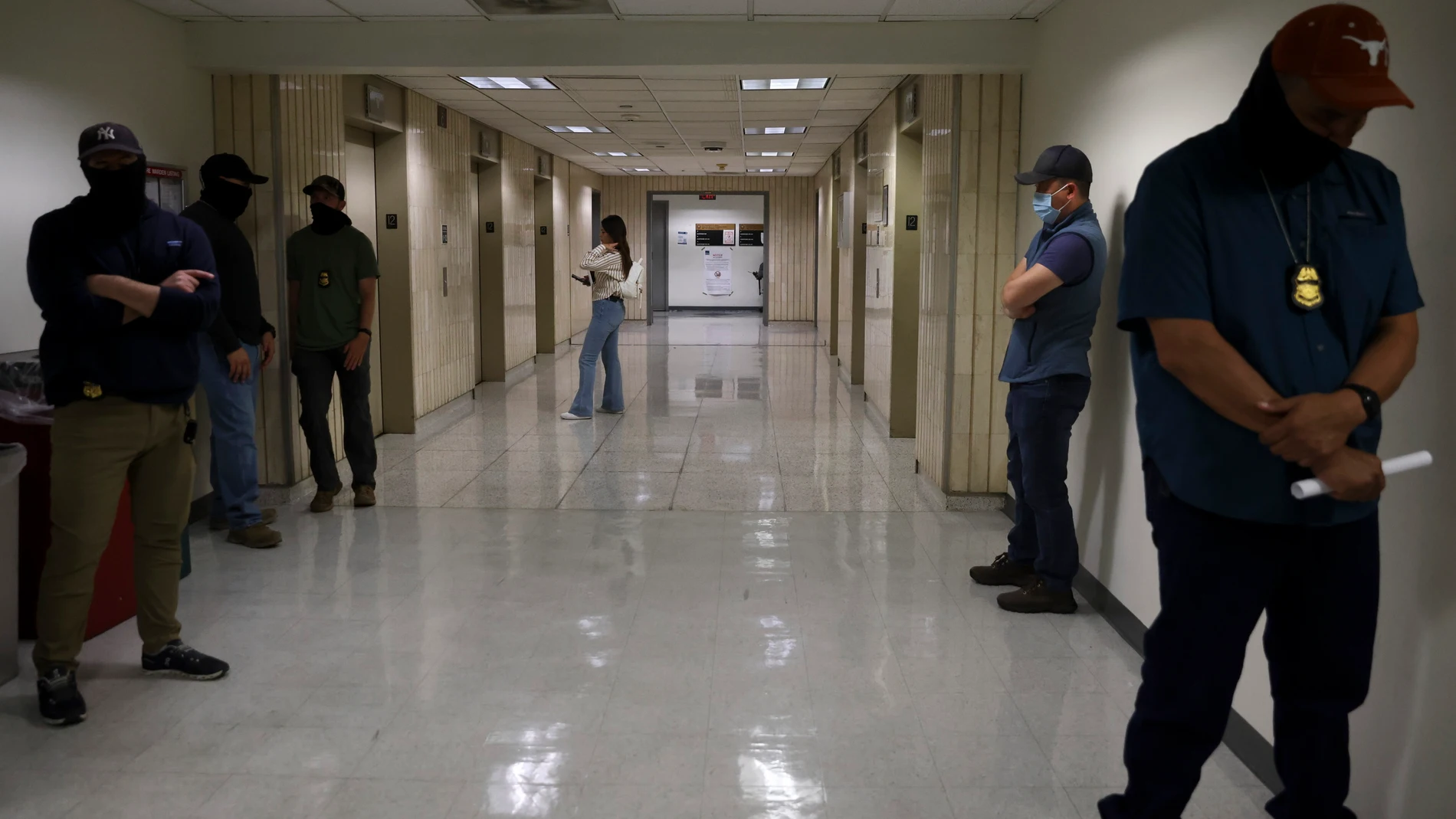 NEW YORK (United States), 20/10/2025.- A visitor waits for the elevator as masked federal officers monitor the hallways outside of immigration court at the Jacob K. Javits Federal Building in New York, New York, USA, 20 October 2025. Detentions of immigrants by federal agents occur almost every working day in the hallways of the immigration courts inside the Javits federal building. (Nueva York) EFE/EPA/SARAH YENESEL