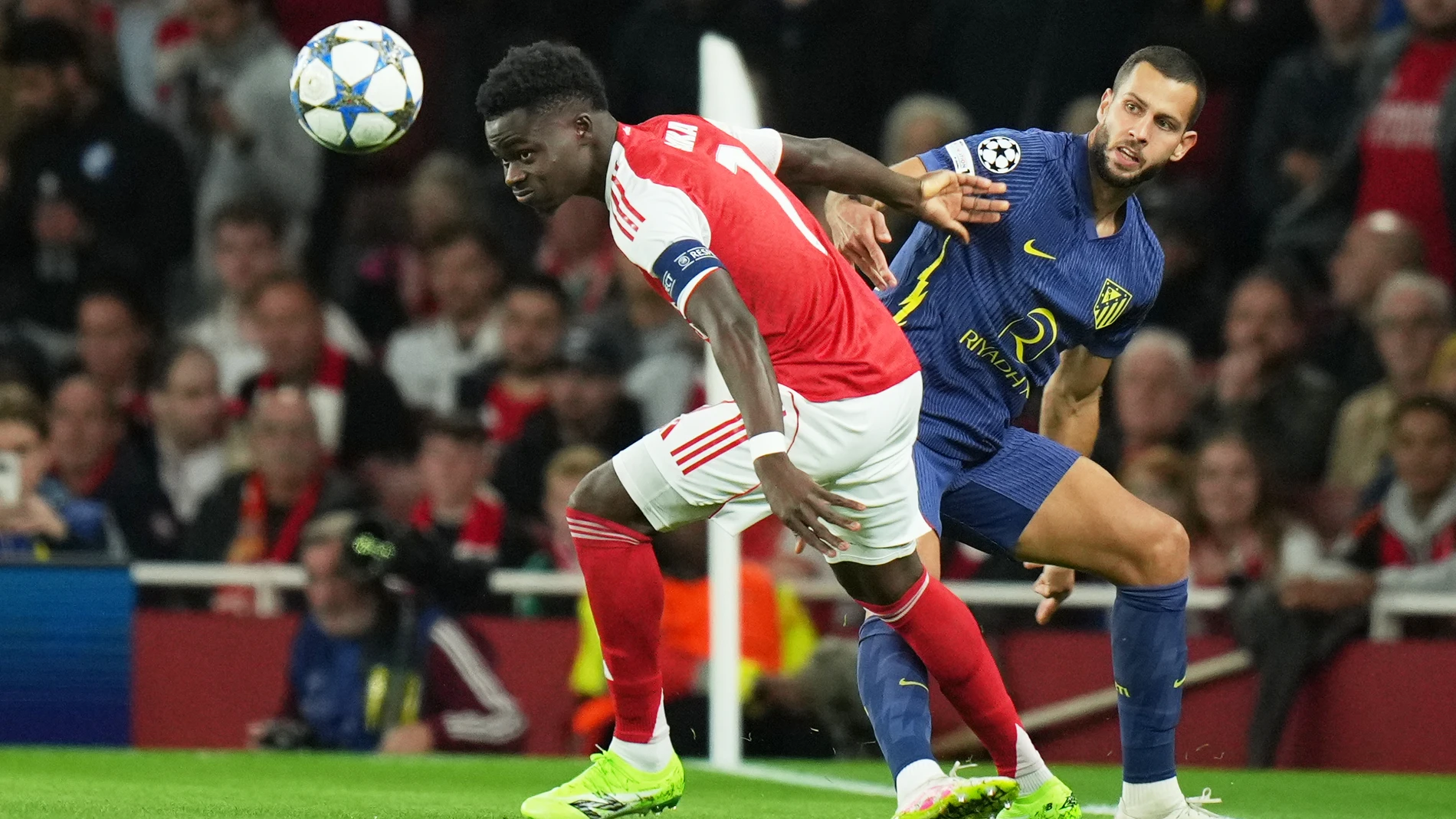 Arsenal's Bukayo Saka, left, duels for the ball with Atletico Madrid's David Hancko during the Champions League opening phase soccer match between Arsenal and Atletico Madrid in London, England, Tuesday, Oct. 21, 2025. (AP Photo/Alastair Grant)