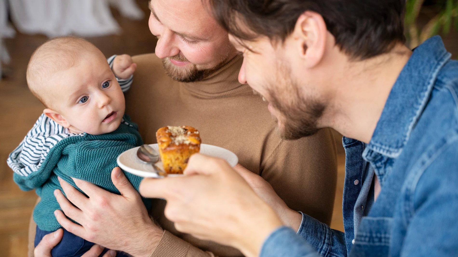 Bebé con sus padres comiendo alimento poco saludable