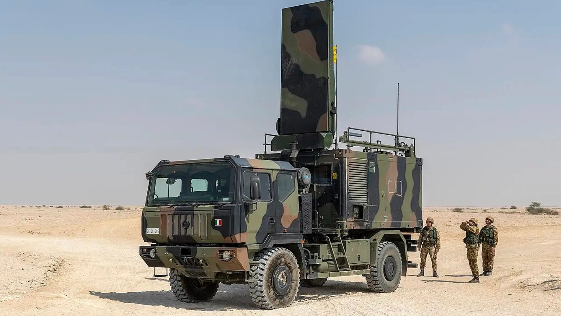 Camión militar pintado de camuflaje en unas maniobras en un entorno desértico