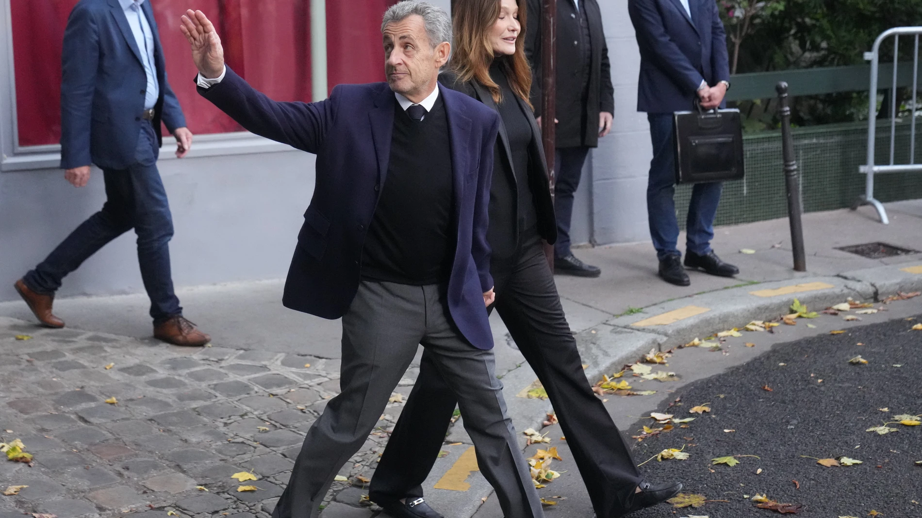 Former French President Nicolas Sarkozy and his wife Carla Bruni-Sarkozy leave their home Tuesday, Oct. 21, 2025 in Paris as Nicolas Sarkozy heads to prison to serve time for a criminal conspiracy to finance his 2007 election campaign with funds from Libya. (AP Photo/Thibault Camus)