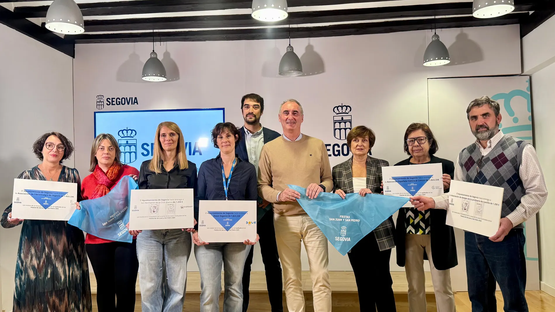 El alcalde de Segovia, José Mazarías, y el concejal de Festejos Patronales, Gabriel Cobos, hacen entrega de los cheques correspondientes a la recaudación obtenida con la venta de los pañuelos de las Ferias y Fiestas de San Juan y San Pedro 2025