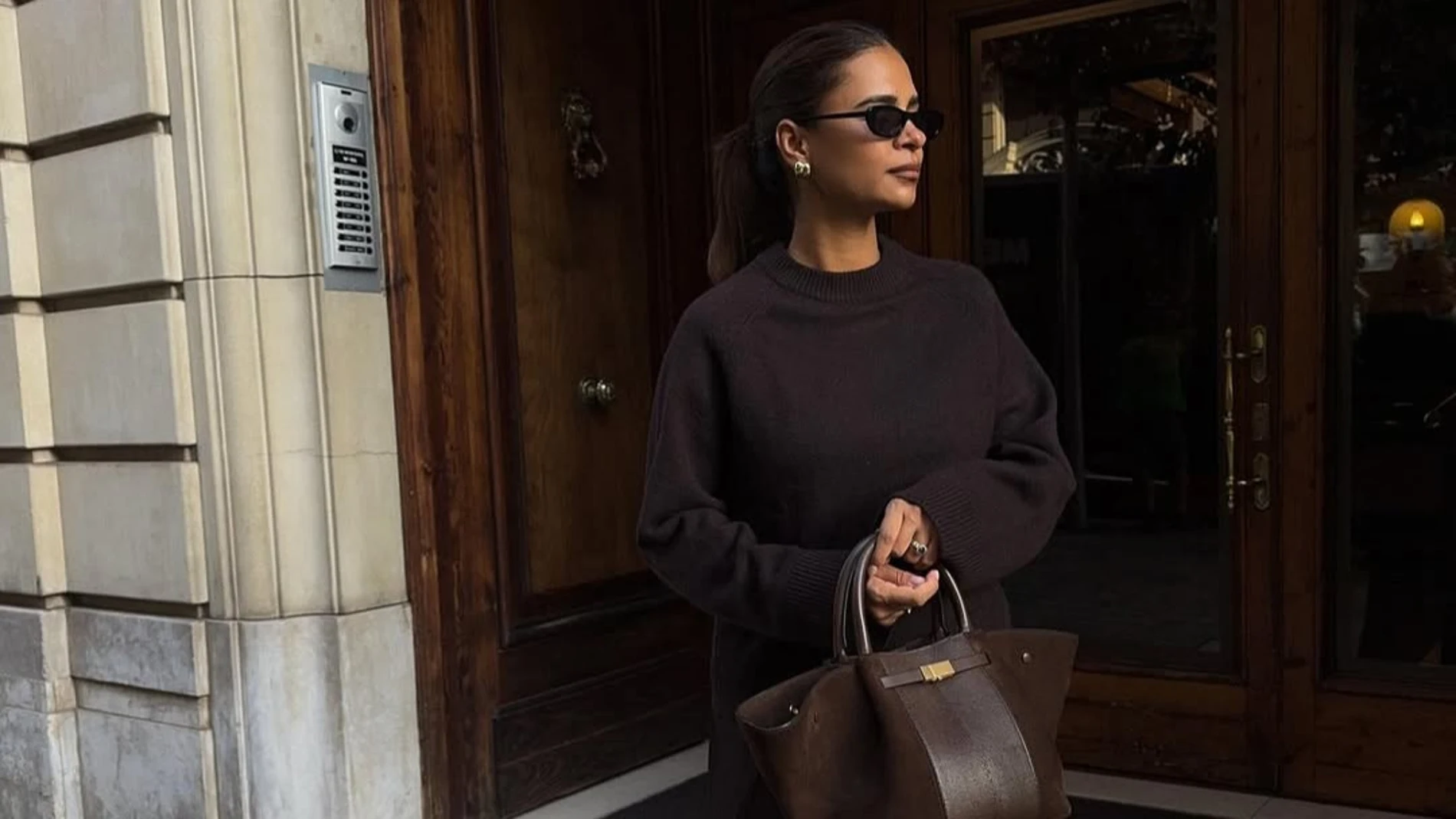 Emelie Lindmark con jersey de punto marrón y bolso beige, look otoñal