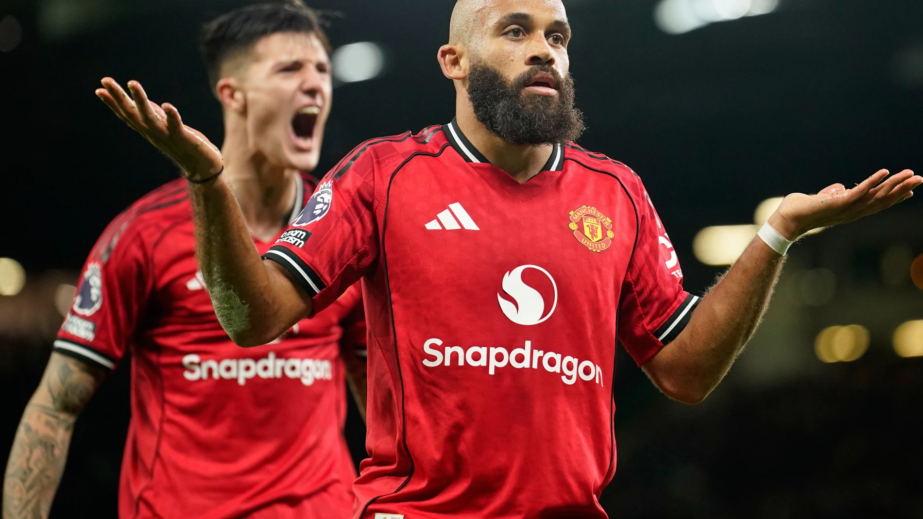 Manchester United's Bryan Mbeumo, front, celebrates with Benjamin Sesko after scoring his side's third goal during the English Premier League soccer match between Manchester United and Brighton & Hove Albion in Manchester, England, Saturday, Oct. 25, 2025. (AP Photo/Dave Thompson)