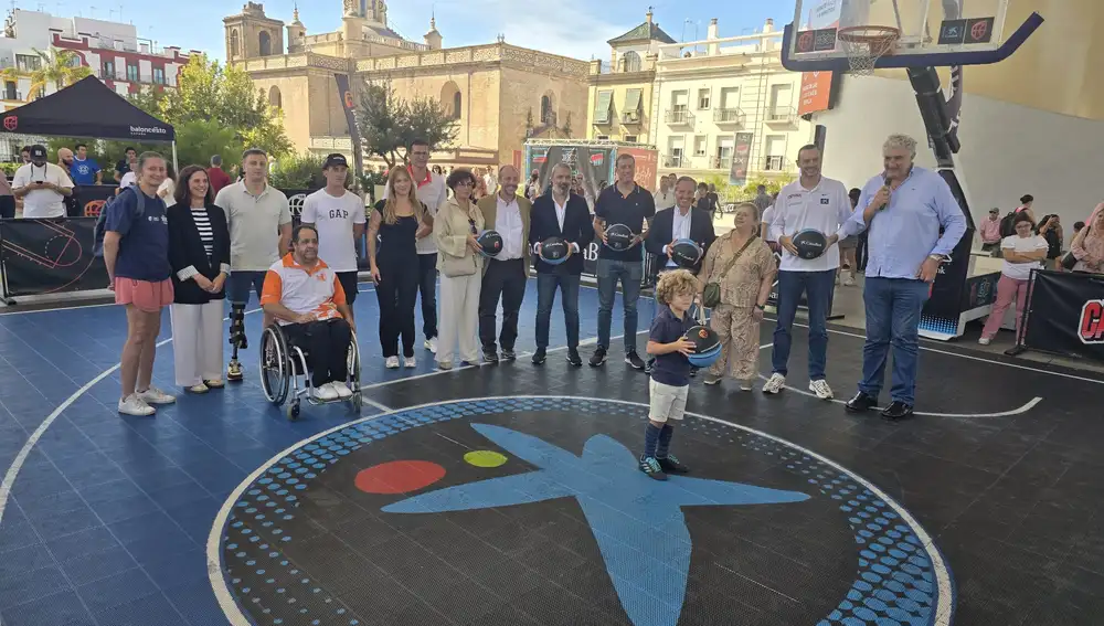 El niño Arturo con el balón de baloncesto como metáfora del futuro junto a las autoridades y ex jugadores