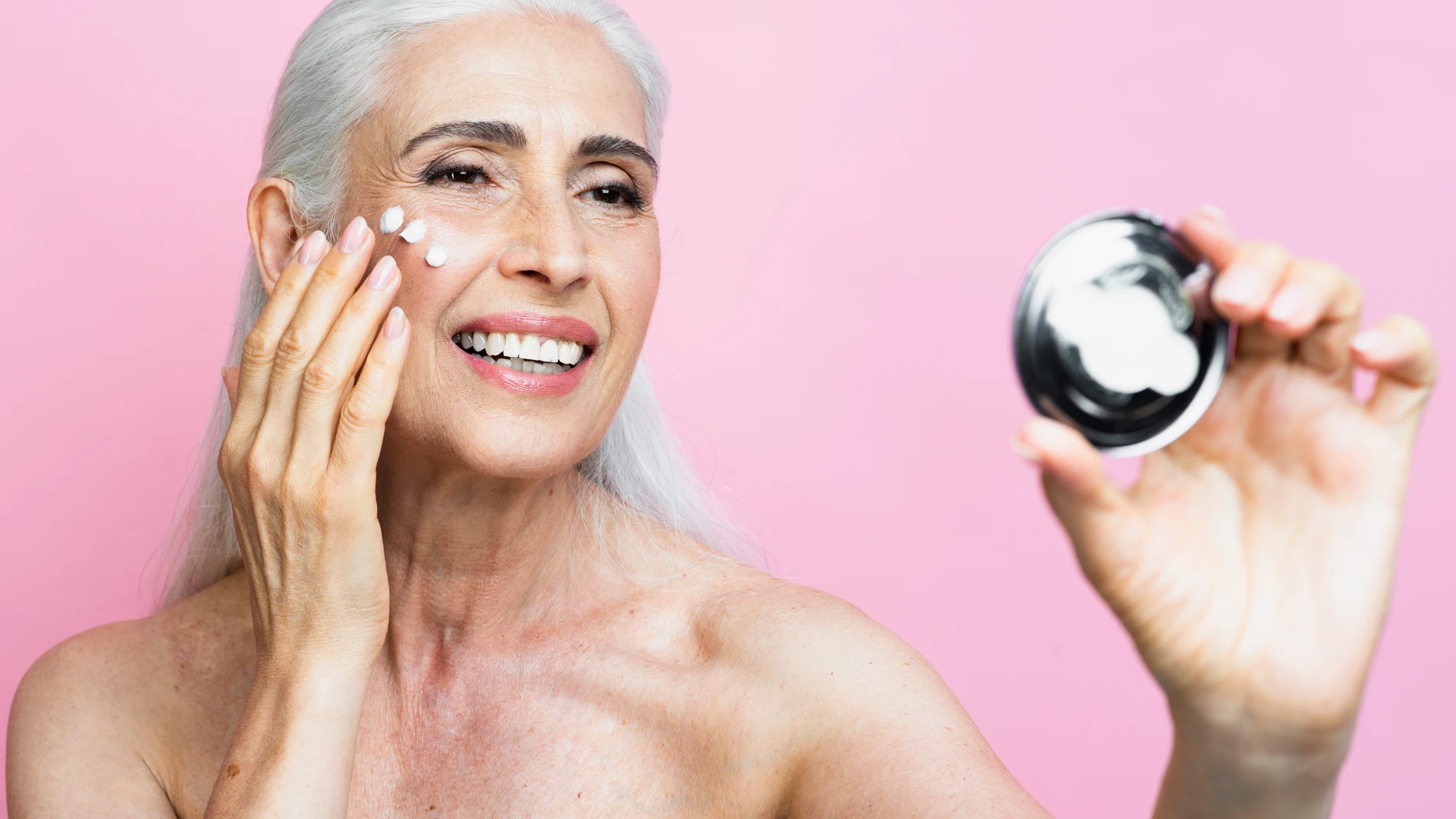 Mujer madura usando cosméticos