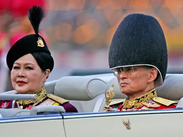 La reina madre de Tailandia y el rey Bhumibol Adulyadej en un desfile militar en 2006 FILE - Late Thai King Bhumibol Adulyadej, right, and then Queen Sirikit attend the annual military parade to celebrate the king's 79th birthday in Bangkok Dec. 2, 2006. Sirikit Kitiyakara, who supervised royal projects to help the rural poor, preserve traditional craft-making and protect the environment, died on Friday, Oct. 24, 2025. She was 93. (AP Photo/Sakchai Lalit, File)
