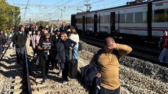 Los viajeros afectados, andando por las vías del tren