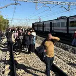 Los viajeros afectados, andando por las vías del tren
