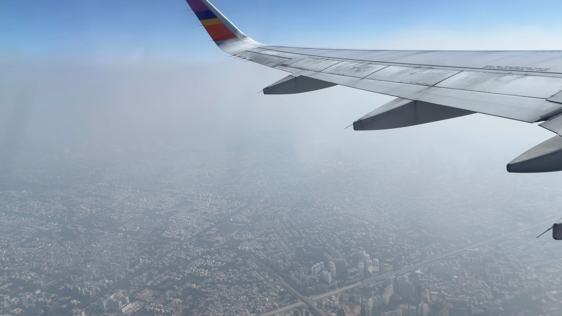 A layer of smog hangs over the skyline as seen from an aircraft window in New Delhi, India, Sunday, Oct. 26, 2025. (AP Photo/Yirmiyan Arthur)