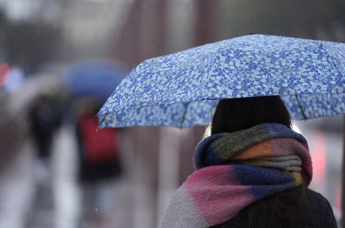 Imagen de archivo. Una persona se protege de la lluvia con un paraguas Imagen de archivo. Una persona se protege de la lluvia con un paraguas