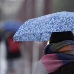 Imagen de archivo. Una persona se protege de la lluvia con un paraguas