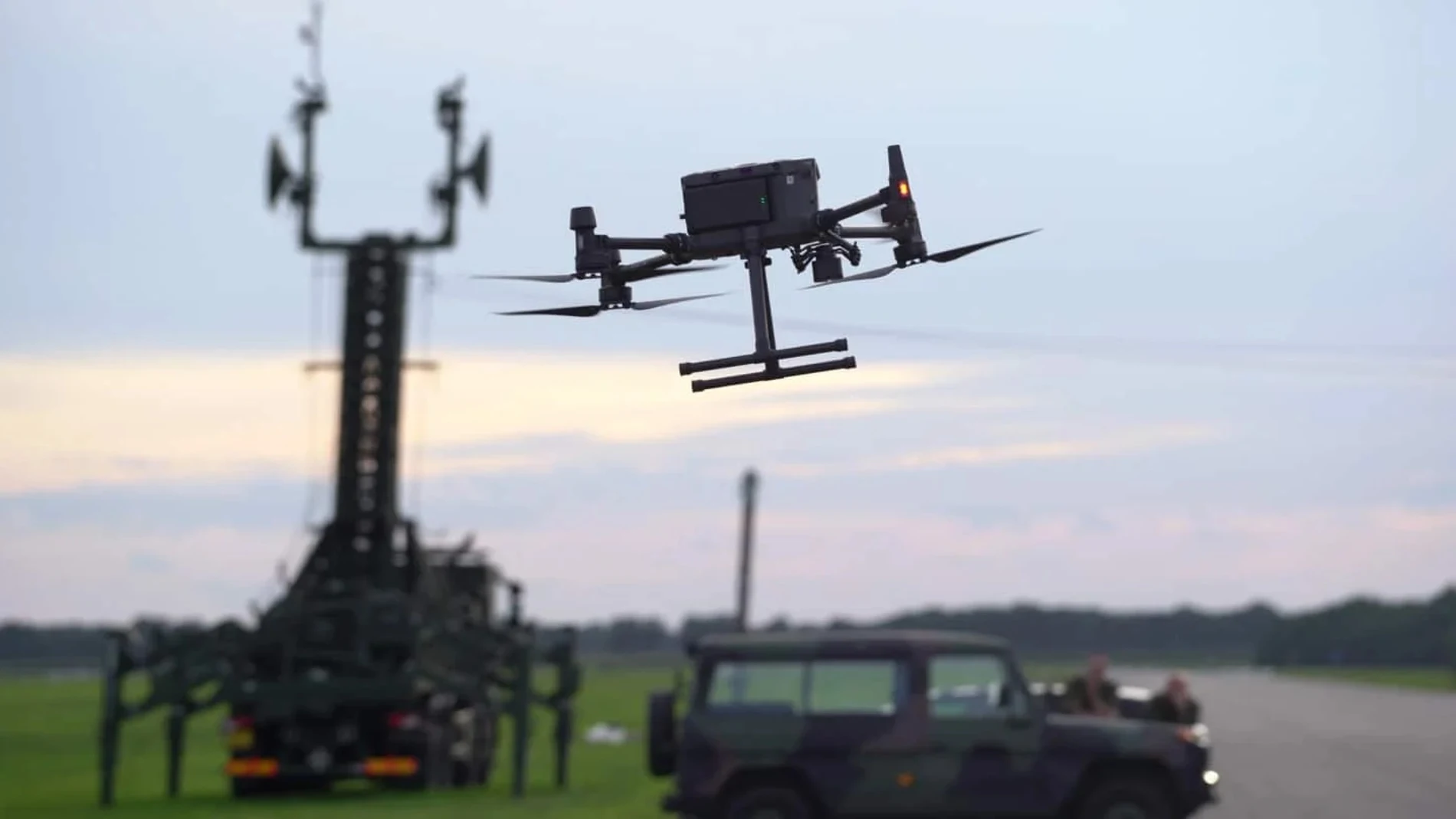 Sistema de radares y un dron volando frente a una estación de vigilancia