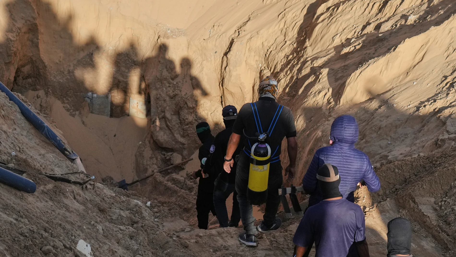 Members of the al-Qassam Brigades, the military wing of Hamas search for the bodies of hostages in a tunnel discovered during searches in Hamad City, Khan Younis, in the southern Gaza Strip, on Tuesday, Oct. 28, 2025. (AP Photo/Jehad Alshrafi)