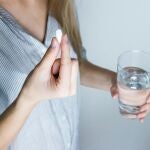 Mujer tomándose una pastilla Mujer tomándose una pastilla