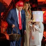 President DONALD TRUMP speaks to a trick-or-treater dressed as a marshmallow while First Lady MELANIA TRUMP laughs at the 2025 White House Halloween event.