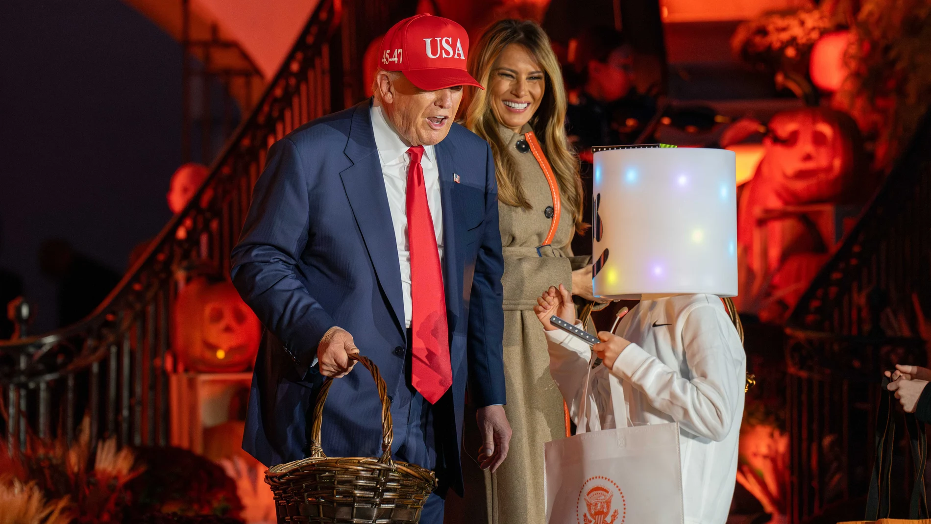 President DONALD TRUMP speaks to a trick-or-treater dressed as a marshmallow while First Lady MELANIA TRUMP laughs at the 2025 White House Halloween event.