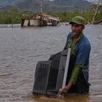 Un hombre traslada un televisor desde su casa inundada por el huracán Melissa en Santiago de Cuba