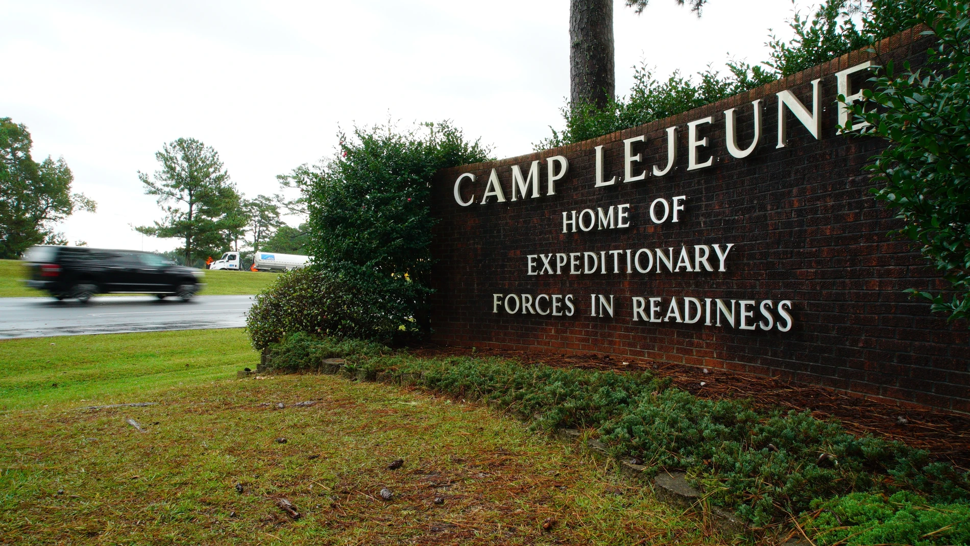 A vehicle drives past an ornamental sign at the main entrance to the Marine Corps base at Camp Lejeune, N.C., on Thursday, Oct. 30, 2025. (AP Photo/Allen G. Breed)