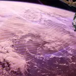 Fotografía de la Tierra con ondas de radio, representadas en morado