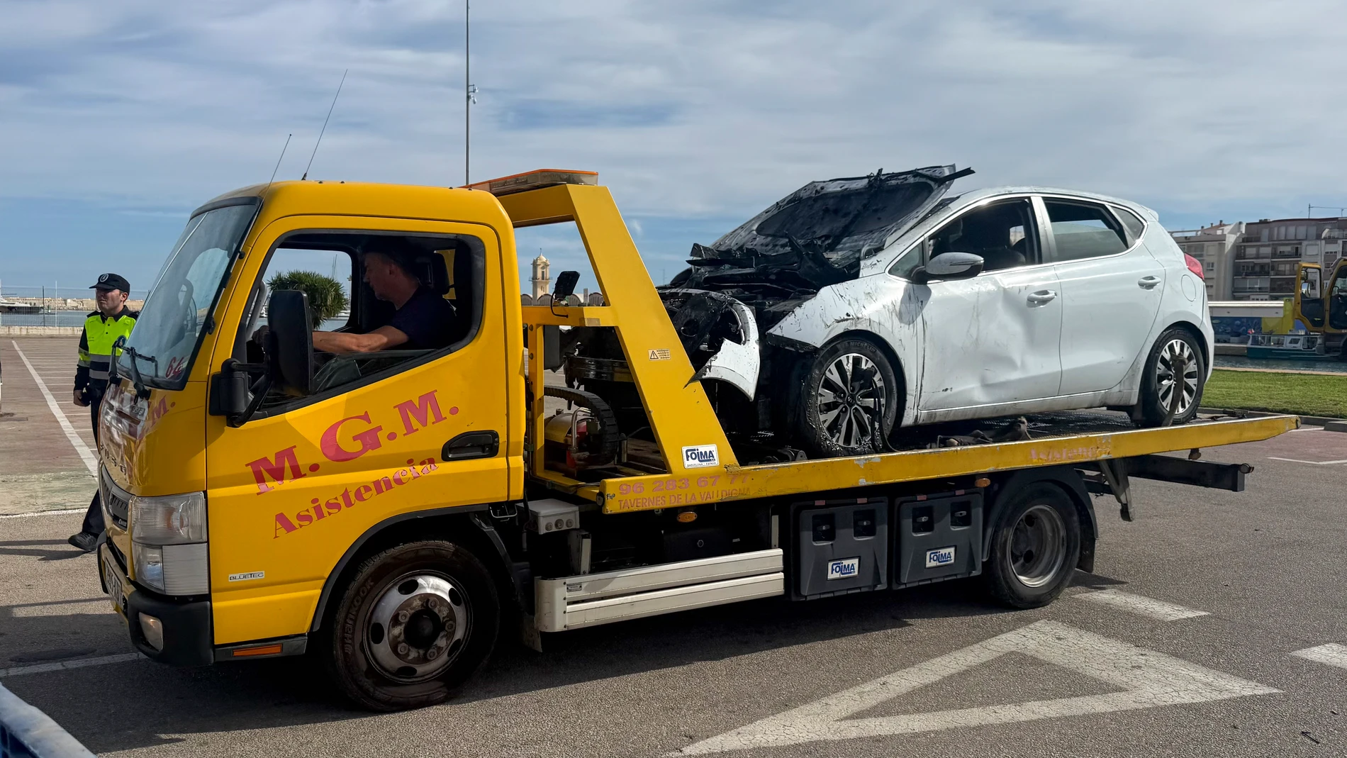 GRAFCVA122. GANDÍA (VALENCIA), 31/10/2025.- Una grúa traslada el coche de la mujer que lo conducía en la noche del jueves cuando cayó en el cauce del río Serpis, en una zona cercana al puerto de Gandia (Valencia), accidente en el que murió una joven de 20 años, por lo que ha sido detenida por la Guardia Civil por los delitos de "homicidio por imprudencia grave y conducir careciendo de permiso y bajo la influencia de bebidas alcohólicas y drogas tóxicas". EFE/Raquel Segura