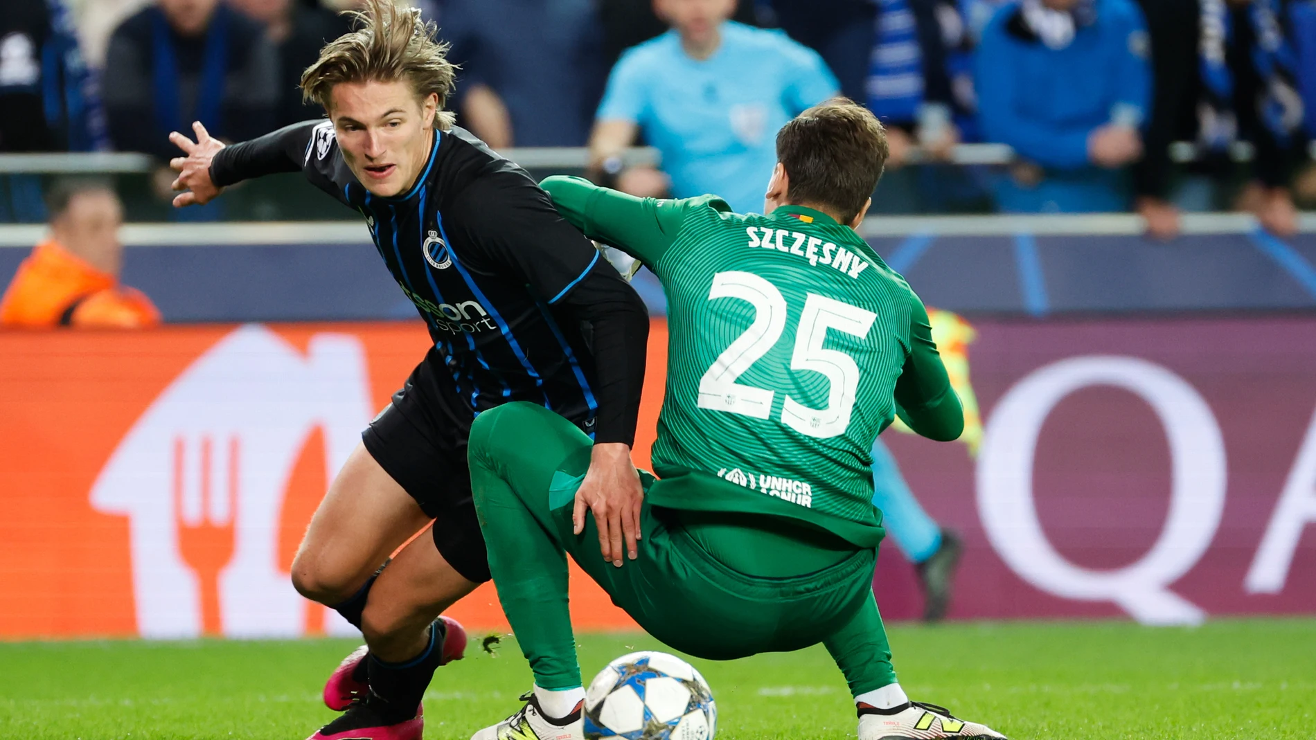 Brugge's Romeo Vermant, left, and Barcelona's goalkeeper Wojciech Szczesny tussle for the ball during the Champions League opening phase soccer match between Club Brugge and Barcelona in Bruges, Belgium, Wednesday, Nov. 5, 2025. (AP Photo/Geert Vanden Wijngaert)