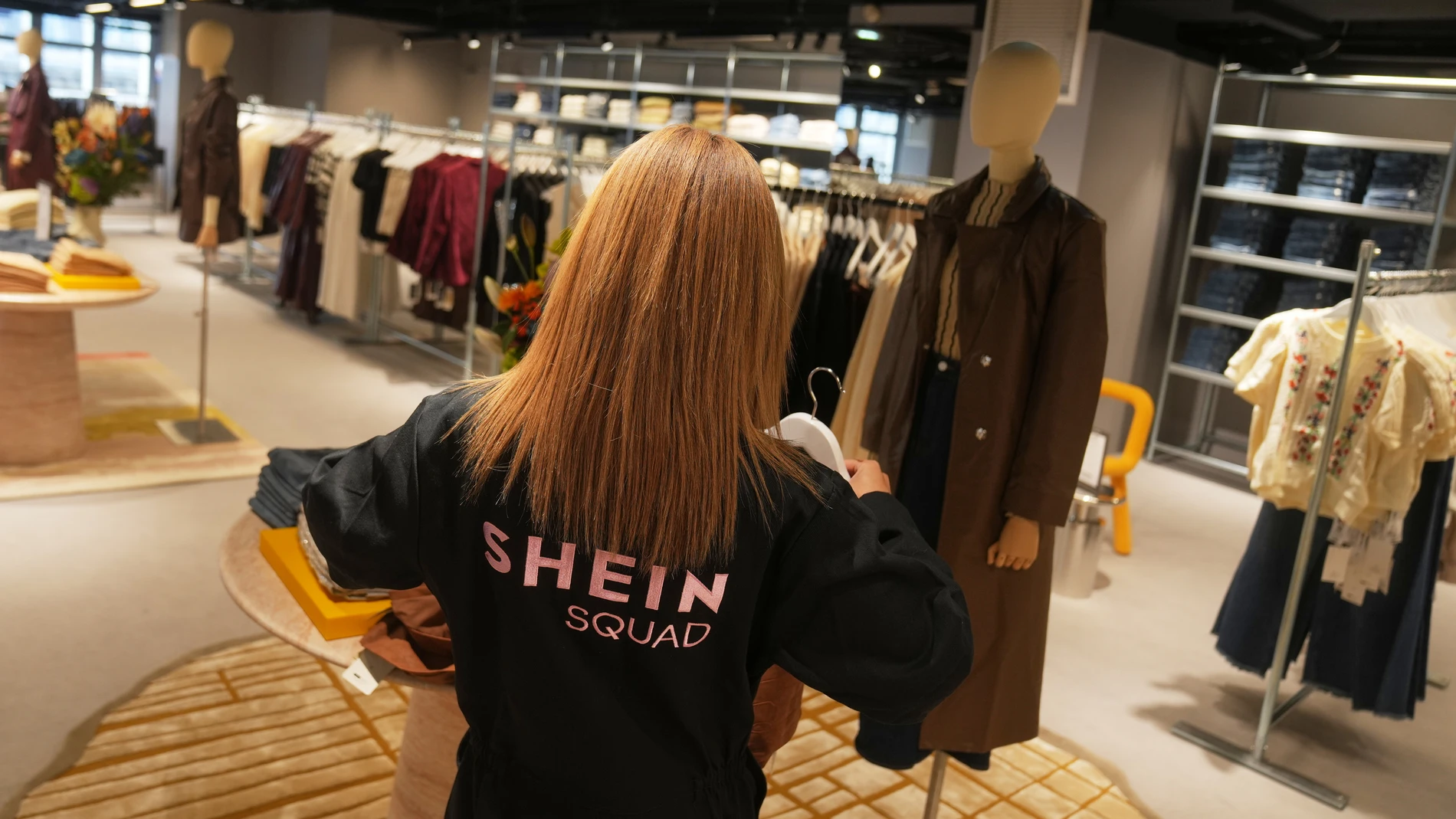 An employee arranges clothes at the BHV department store where fast fashion powerhouse Shein's first permanent store is set to open, Wednesday, Nov. 5, 2025 in Paris. (AP Photo/Thibault Camus)