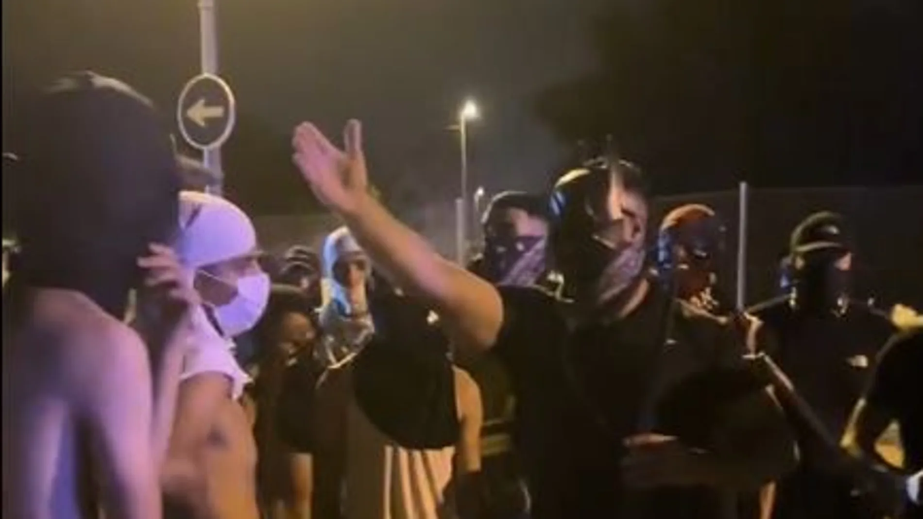 Grupos de magrebíes con capuchas durante los incidentes atienden la arenga del cabecilla, «Batmoro»