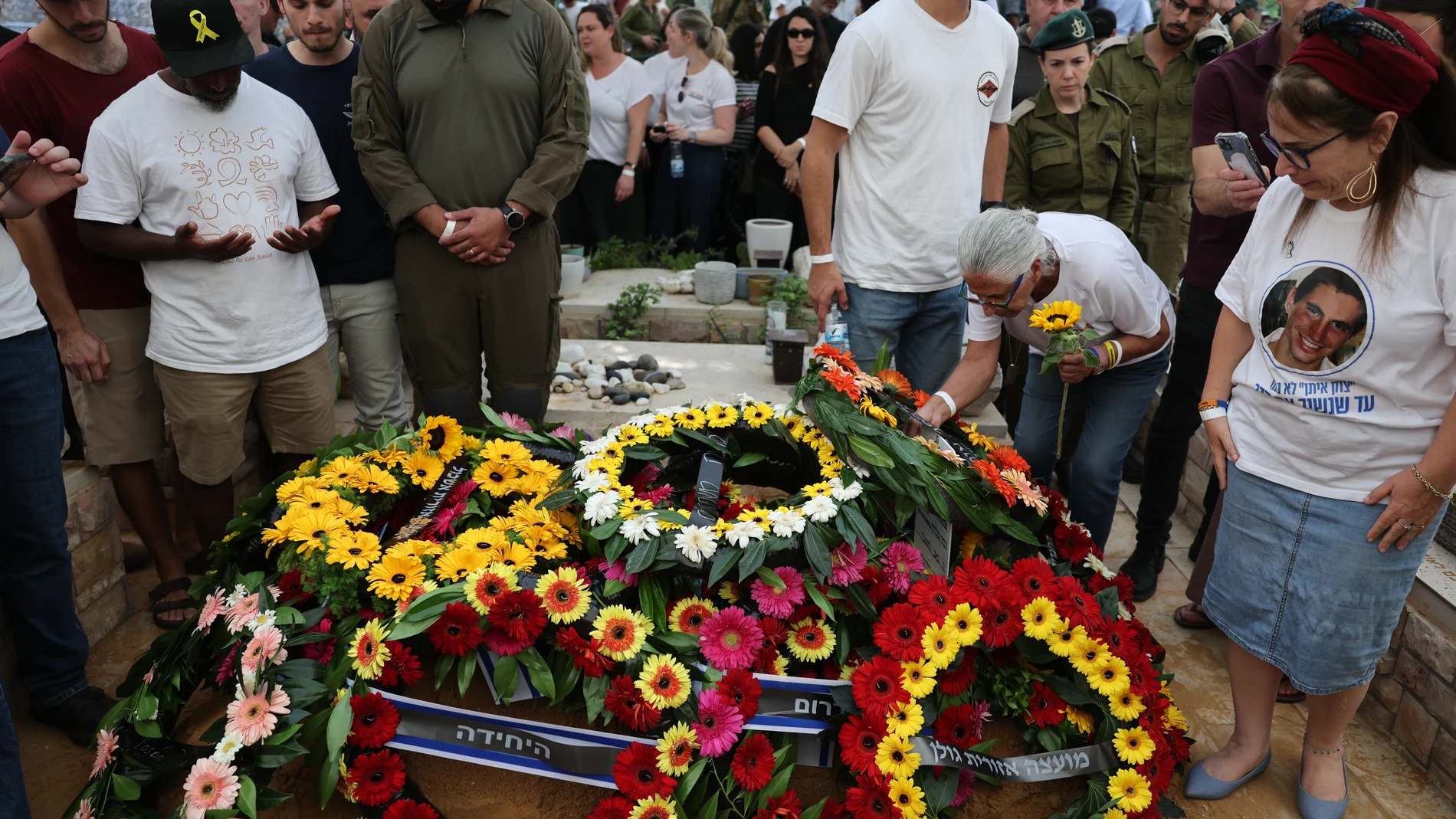 People lays wreaths on the grave of Hadar Goldin an Israeli soldier killed in Gaza in 2014 and whose body had been held there until it was released Sunday, during his funeral in Kfar Saba, Israel, Tuesday, Nov. 11, 2025. (Abir Sultan/Pool via AP)