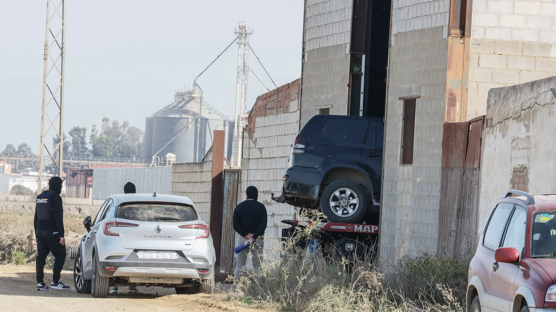 ISLA MAYOR (SEVILLA), 11/11/2025.- Agentes de Policía sacan un vehículo de las naves en Isla Mayor (Sevilla), incautado en la operación policial que sigue abierta para detener a los narcos que abrieron fuego contra los agentes cuando estos trataban de registrar una "guardería" de droga en una nave industrial del municipio. EFE/ Jose Manuel Vidal
