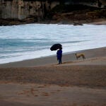 Una mujer observa el mar desde la playa del Orzán, en A Coruña.