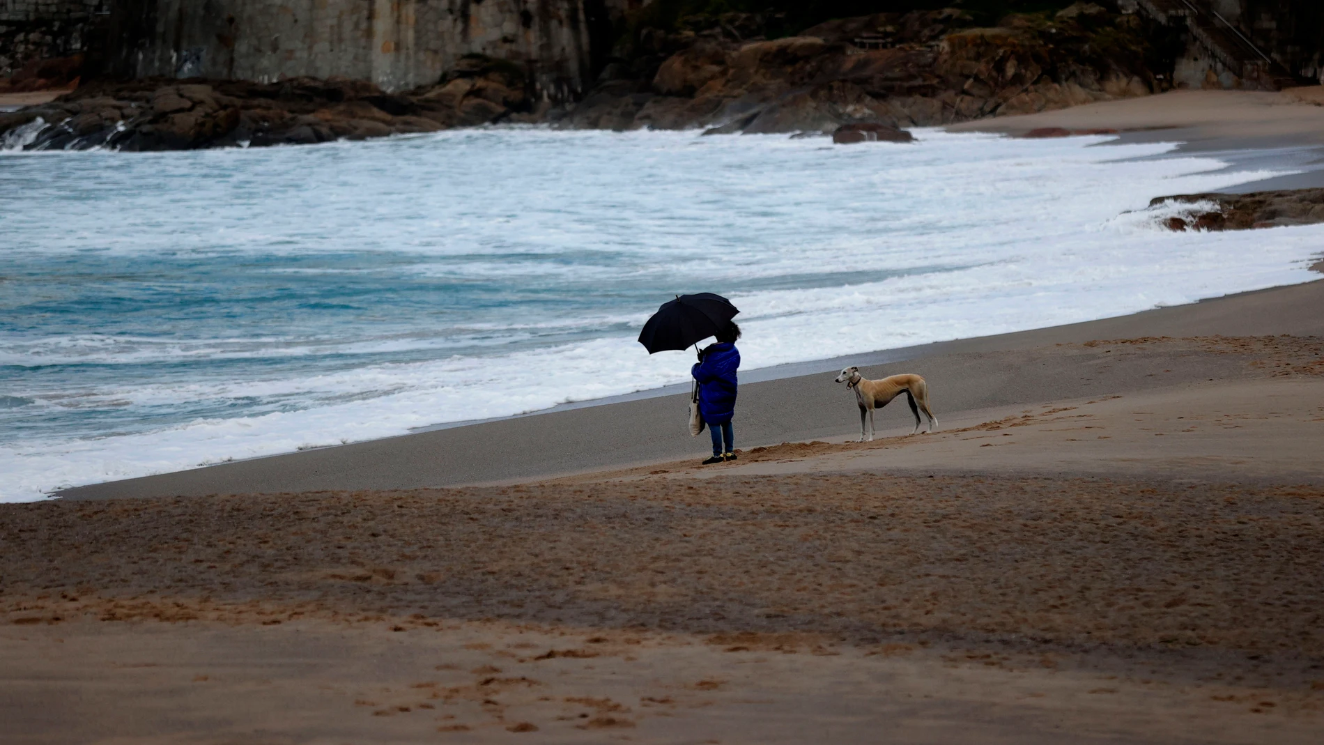 FOTODELDÍA A CORUÑA (ESPAÑA), 11/11/2025.- Una mujer observaba el mar este martes desde la playa del Orzán, en A Coruña, donde la tormenta Claudia empieza a dejarse sentir con lluvias y fuertes vientos en la costa de Galicia, donde permanece activa la alerta naranja por oleaje y mar de viento en toda la costa, a excepción de la Mariña lucense, donde el qviso es de nivel amarillo. EFE/Cabalar