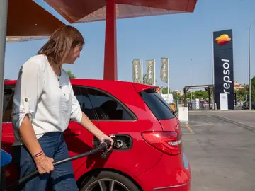 Mujer repostando en una estación de servicio Repsol Mujer repostando en una estación de servicio Repsol