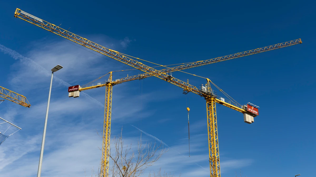 Construcción de nuevas viviendas. Gruas y obreros en la obras de nuevos edificios.