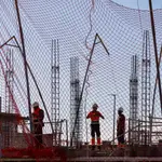 Construcción de nuevas viviendas. Gruas y obreros en la obras de nuevos edificios.