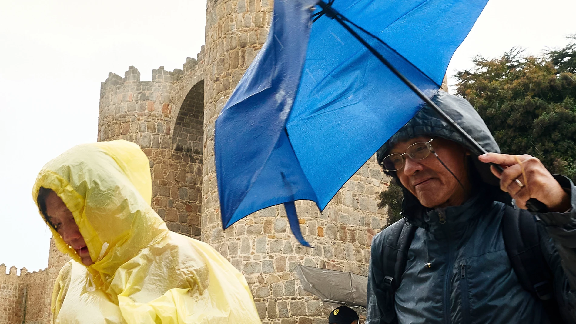 ÁVILA, 13/11/2025.- Dos personas se protegen de la lluvia este juves en Ávila. Castilla y León se encuentra este jueves en aviso, entre amarillo y naranja, por lluvias y viento, con precipitaciones especialmente intensas en las provincias de Ávila y Salamanca, donde se podrían acumular entre 80 y 100 litros por metro cuadrado en 12 horas. EFE/Raúl Sanchidrián