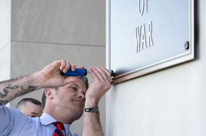 El secretario de Guerra, Pete Hegseth, termina de colocar uno de los carteles El secretario de Guerra, Pete Hegseth, termina de colocar uno de los carteles