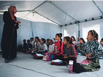 Estudiantes gazatíes asisten a clase dentro de una tienda de campaña instalada en la playa de Jan Yunis Estudiantes gazatíes asisten a clase dentro de una tienda de campaña instalada en la playa de Jan Yunis