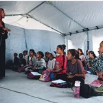 Estudiantes gazatíes asisten a clase dentro de una tienda de campaña instalada en la playa de Jan Yunis