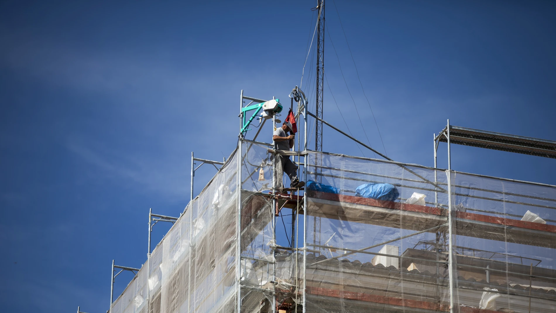 Un obrero en lo alto del andamio en un edificio en rehabilitación. en Madrid.
