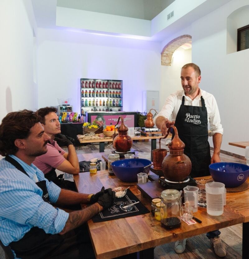 Visitantes de la destilería haciendo su propia ginebra con la ayuda de un experto