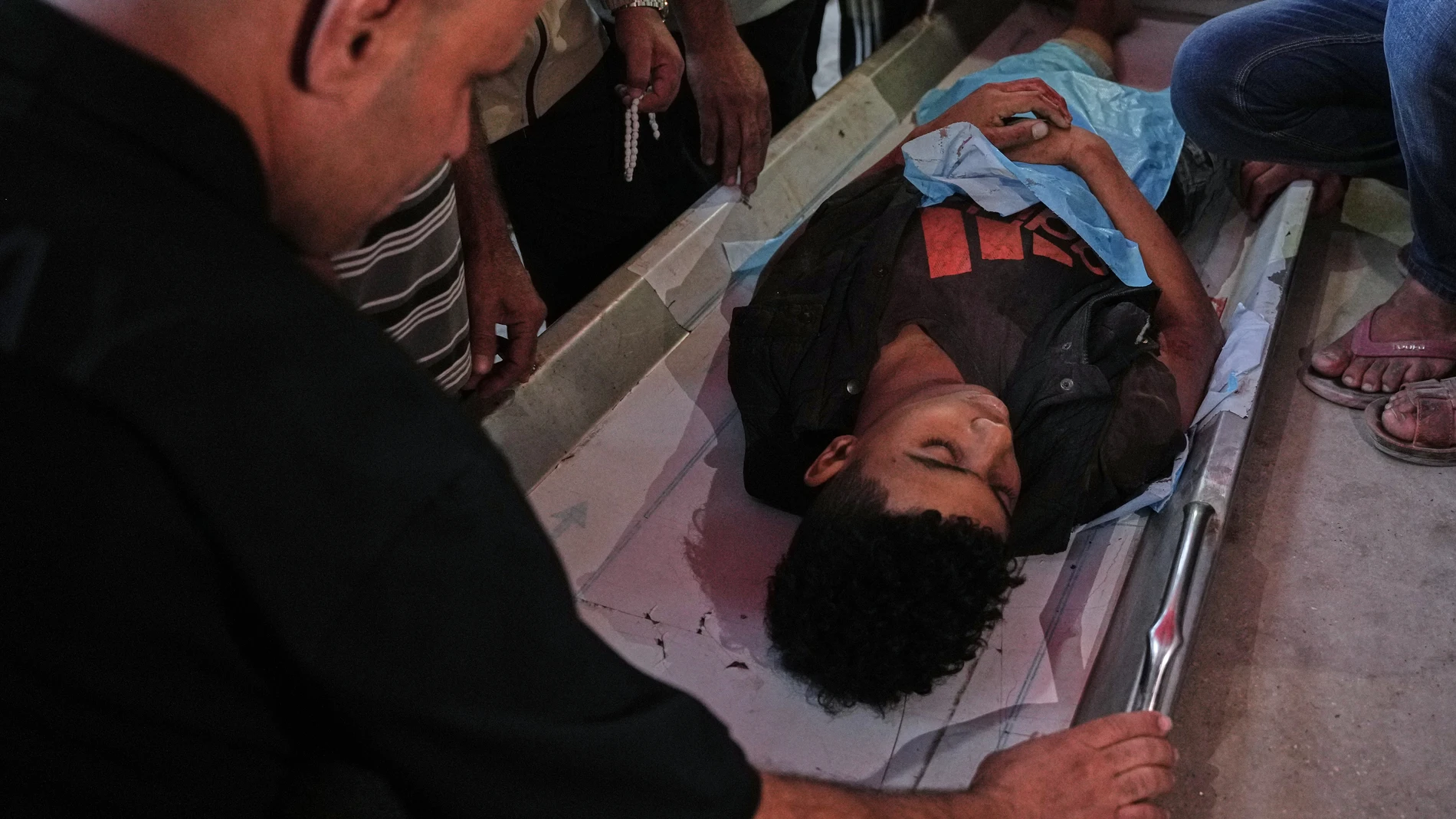 Relatives mourn over the body of a Palestinian killed in Israeli strikes on the Gaza Strip at Al-Aqsa Hospital in Deir al-Balah, Saturday, Nov. 22, 2025. (AP Photo/Abdel Kareem Hana)