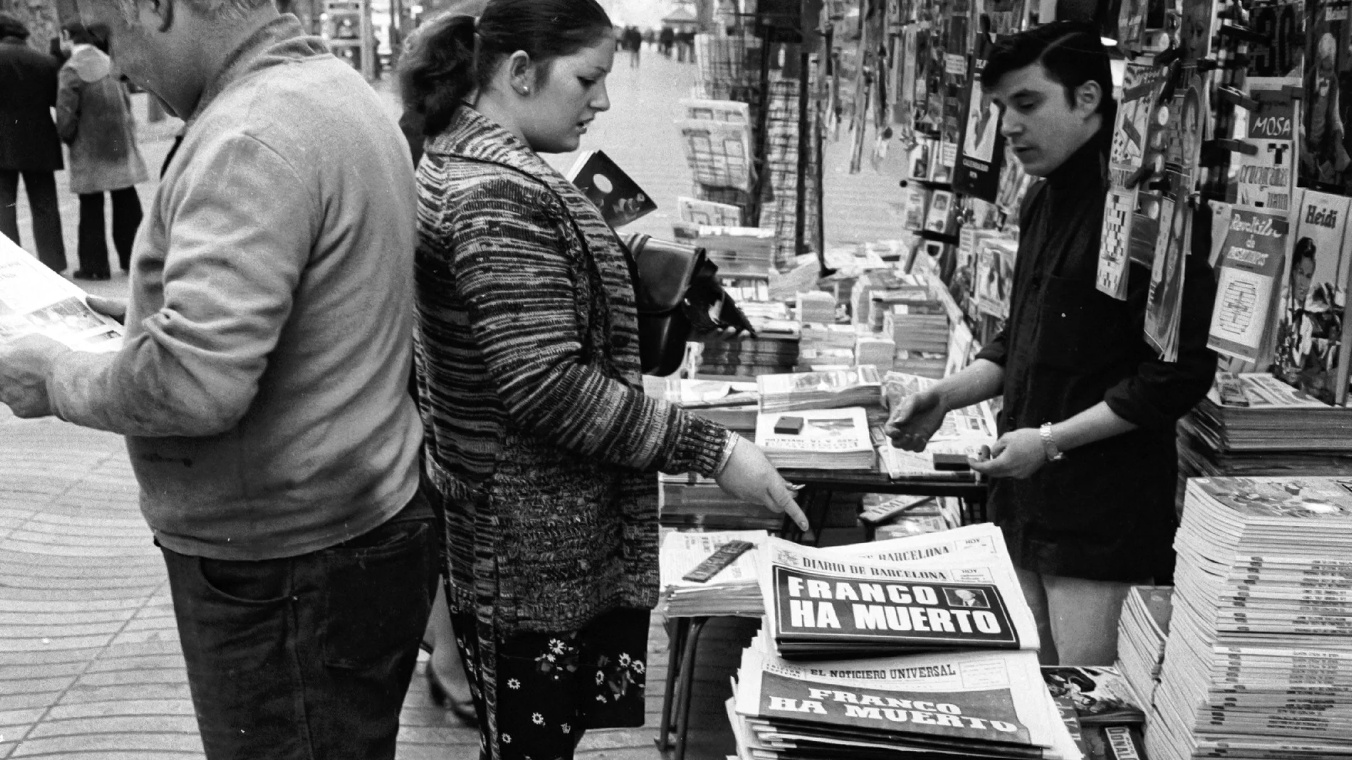 Transeúntes compran la prensa en un kiosco de Las Ramblas para informarse en los periódicos de la noticia de la muerte de Francisco Franco el día anterior. TRANSICIÓN ESPAÑOLA;POLÍTICA;PRENSA;COBERTURA MEDIÁTICA DE LA MUERTE DE FRANCO Europa Press 21/11/1975