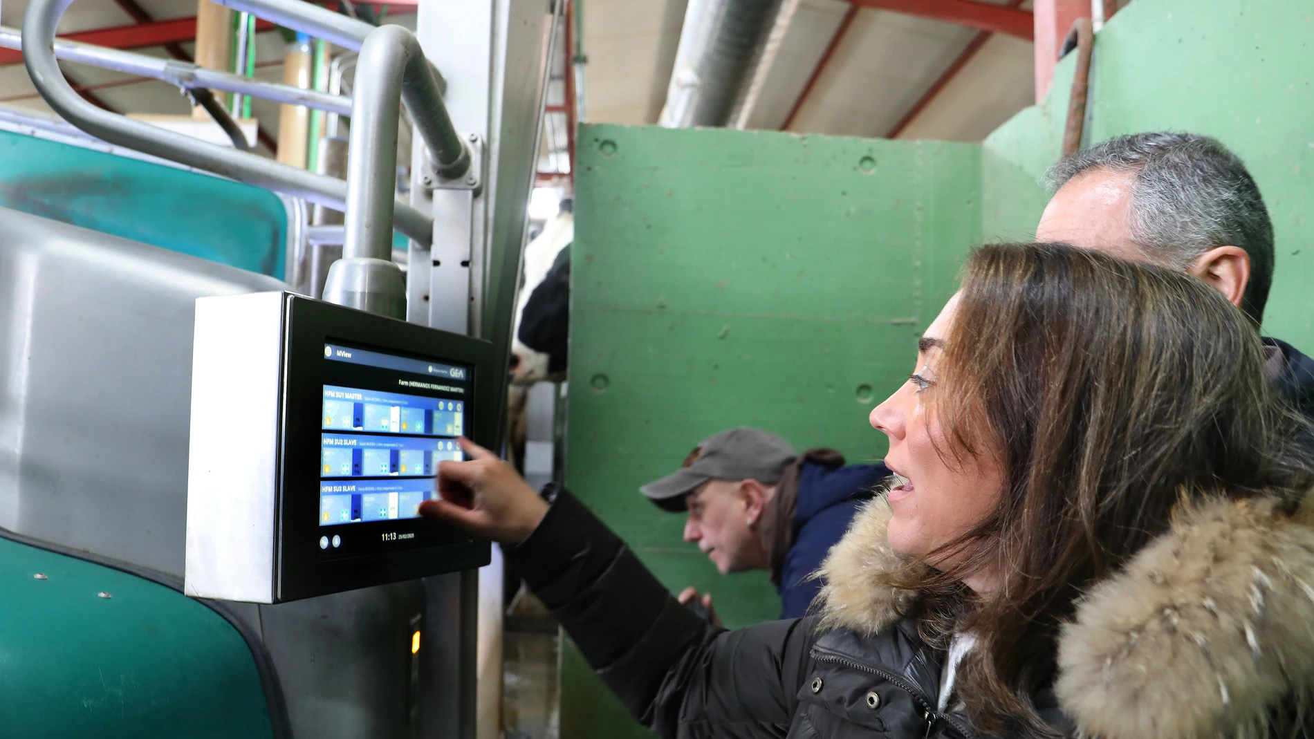 La consejera de Agricultura, Ganadería y Desarrollo Rural, María González Corral, acompañada de Roberto Fernández, uno de los propietarios de la explotación, entre otros, visita una granja de vacuno de leche con un sistema de ordeño único en Castilla y León