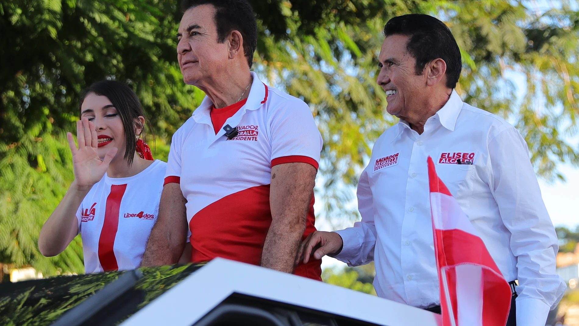 AME1713. TEGUCIGALPA (HONDURAS), 22/11/2025.- El candidato presidencial por el partido Liberal, Salvador Nasralla (c) saluda a personas durante una caravana de cierre de campaña, junto a su esposa Iroska Elvir (i) y el candidato a alcaldía de Tegucigalpa, Eliseo Castro (d), este sábado en Tegucigalpa (Honduras). EFE/ Gustavo Amador